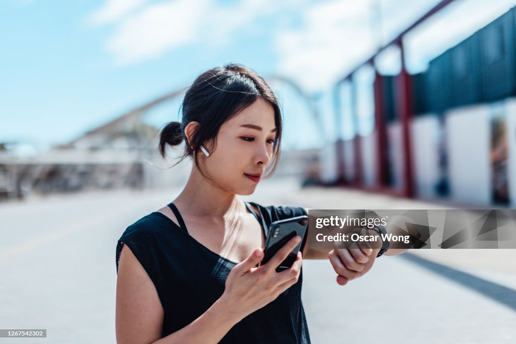 Young woman using smartwatch and doing outdoor workout in the city