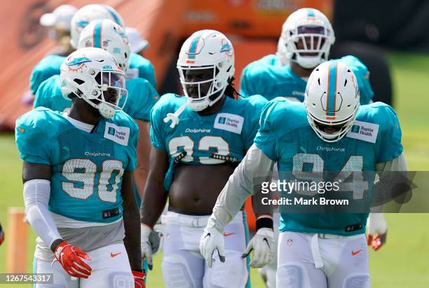 Shaq Lawson, Christian Wilkins, and Brandin Bryant of the Miami Dolphins in between practice drills during training camp at Baptist Health Training...