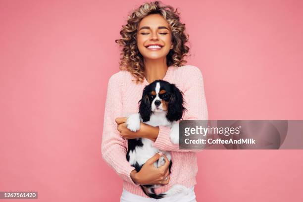 retrato de estúdio de jovem sorridente segurando cachorrinho - little women - fotografias e filmes do acervo