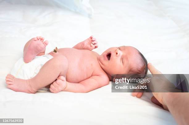 de jongen van de baby met navelstrengstonktront - navel stockfoto's en -beelden