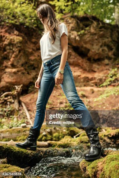 beautiful woman crossing the river - leather boot stock pictures, royalty-free photos & images