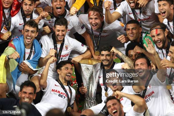 Jesus Navas and Ever Banega of Sevilla, and their teammates celebrate with the UEFA Europa League Trophy following their team's victory in the UEFA...