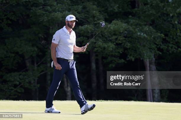 Dustin Johnson of the United States reacts after putting on the 18th hole to finish the day with a 60 during the second round of The Northern Trust...