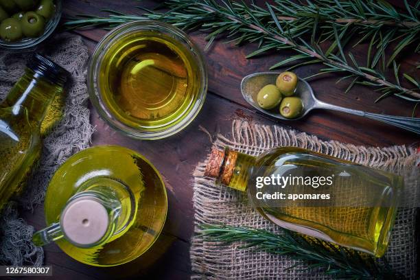 bouteilles d’huile d’olive avec olives. disposer sur la table dans une cuisine rustique à l’ancienne. - olive oil photos et images de collection