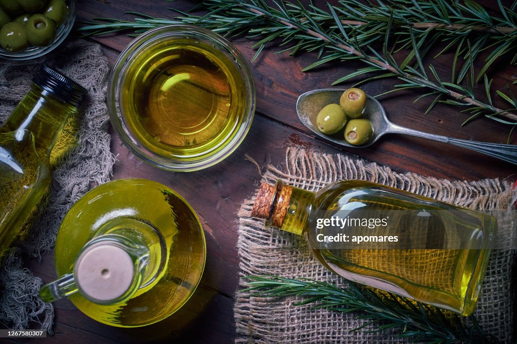 Bottiglie di olio d'oliva con olive. Disporre sul tavolo nella cucina rustica vecchio stile.
