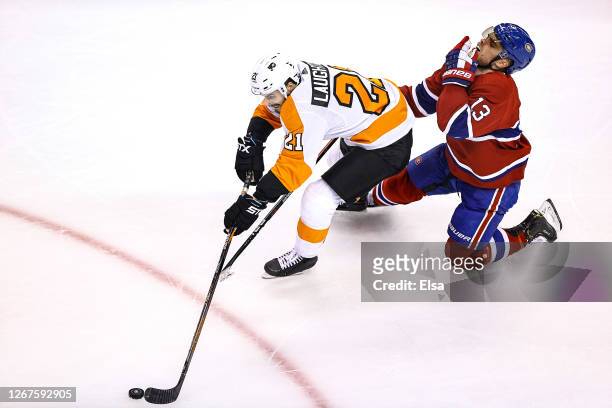 Max Domi of the Montreal Canadiens is hurt as he is called for holding on Scott Laughton of the Philadelphia Flyers during the second period in Game...