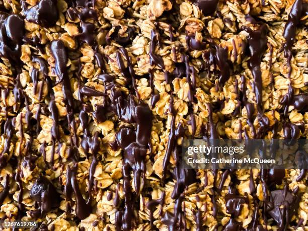 fresh homemade sugar-free oat granola topped with chocolate drizzle - convenience chocolate stock pictures, royalty-free photos & images