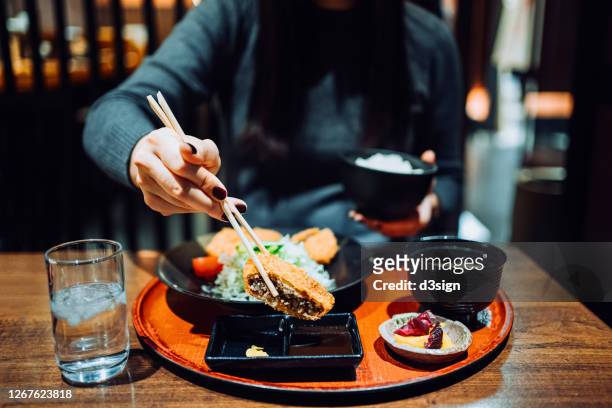 close up of young asian woman enjoying freshly served traditional japanese meal set. miso soup, appetizers and tonkatsu (deep fried pork cutlets) in a japanese restaurant - tonkatsu - fotografias e filmes do acervo