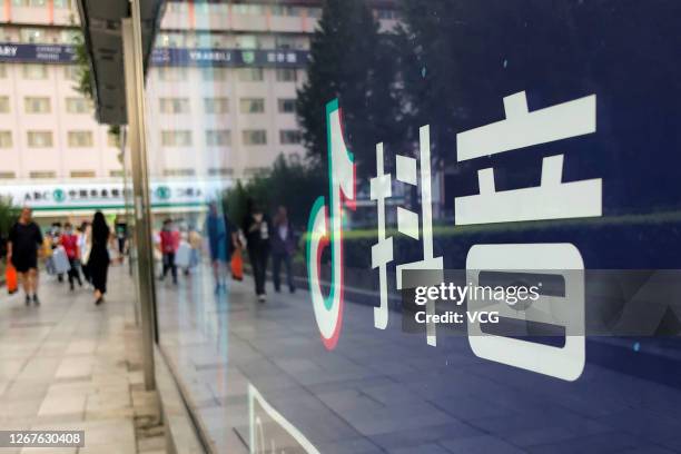 The reflection of pedestrians is seen in a billboard advertising Chinese video app TikTok at Wangfujing street on August 20, 2020 in Beijing, China.
