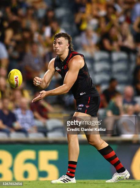 Sam Draper of the Bombers handballs during the round 13 AFL match between the Essendon Bombers and the Richmond Tigers at TIO Stadium on August 22,...