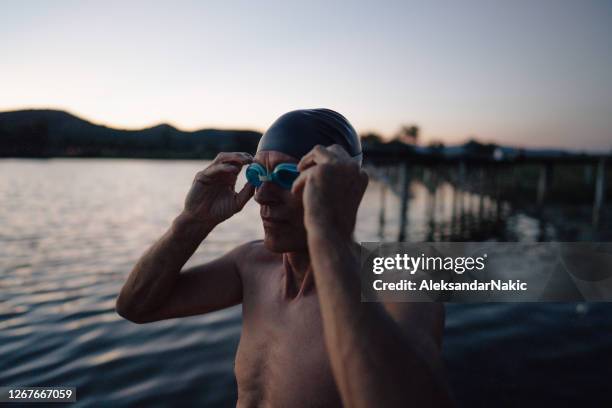 senior swimmer preparing for swimming - swimming cap stock pictures, royalty-free photos & images