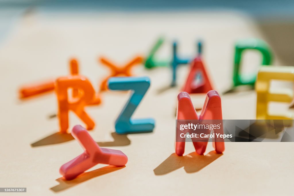 Messy capital plastic letters with shadows.Focus on M