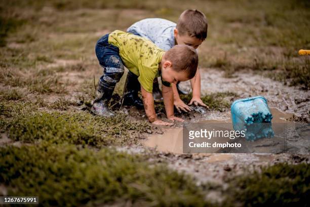 bambini che giocano nel fango - mud foto e immagini stock