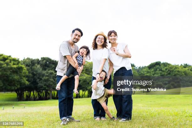 a family taking a walk in the neighborhood park in the evening - japan photos foto e immagini stock