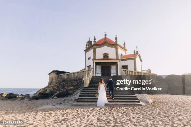 newlywed couple on their wedding day in front of the capela da senhora pedra in porto, portugal - destination wedding imagens e fotografias de stock