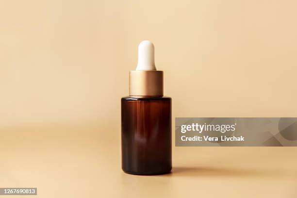 glass cosmetic bottle on brown background. pump bottle, dropper bottle, dispenser cosmetic container flat lay, top view. - hair products fotografías e imágenes de stock