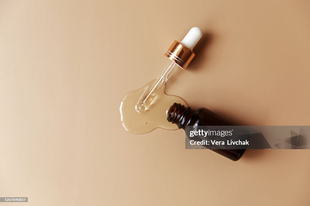 Liquid gel or serum texture with glass Pipette on hell background beauty concept