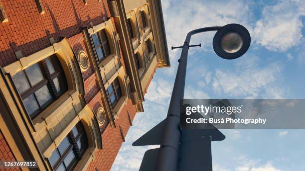 view from below of street lamp and road sign against residential building in berlin, germany - buildings looking up stock pictures, royalty-free photos & images