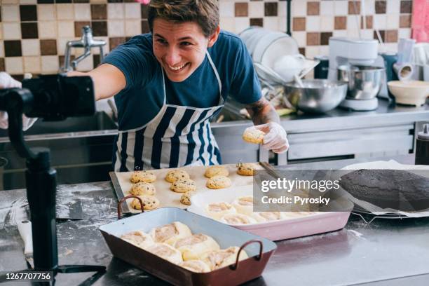 un hombre blogger cocinando en vivo en la cocina para trabajar desde casa. covid-19 - stream fotografías e imágenes de stock