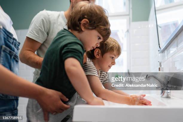 saubere hände sind sichere hände - brothers bathroom stock-fotos und bilder