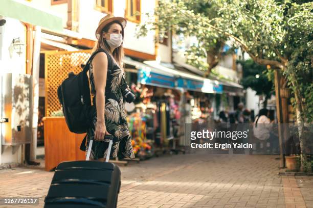 donna turista che indossa una maschera protettiva per il viso ed esplora un nuovo posto - turismo foto e immagini stock