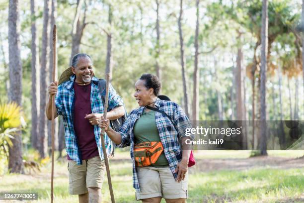 senior african-american couple hiking in park - african american hiking stock pictures, royalty-free photos & images