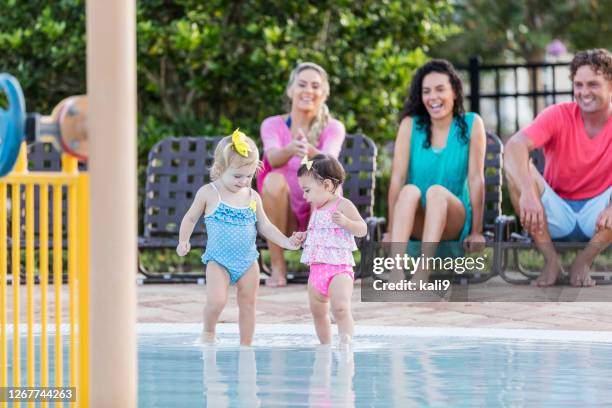 play date at children's pool, little girls holding hands - play date imagens e fotografias de stock