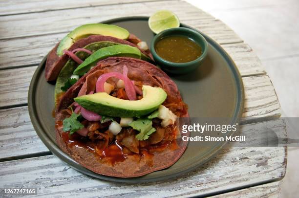 vegetarian jackfruit tacos served with avocado, pickled onions and coriander and salsa verde - jackfruit foto e immagini stock
