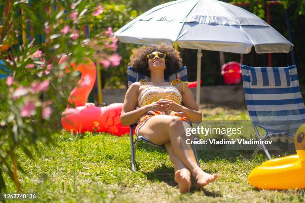 young girl having sun bath in her back yard - sun bathing backyard stock pictures, royalty-free photos & images