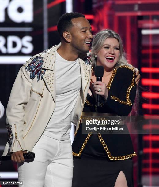 Recording artists John Legend and Kelly Clarkson speak during the 2018 Billboard Music Awards at MGM Grand Garden Arena on May 20, 2018 in Las Vegas,...