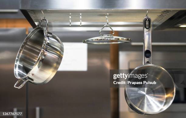 stainless steel kitchenware hang on steel bar - pan keukengereedschap stockfoto's en -beelden