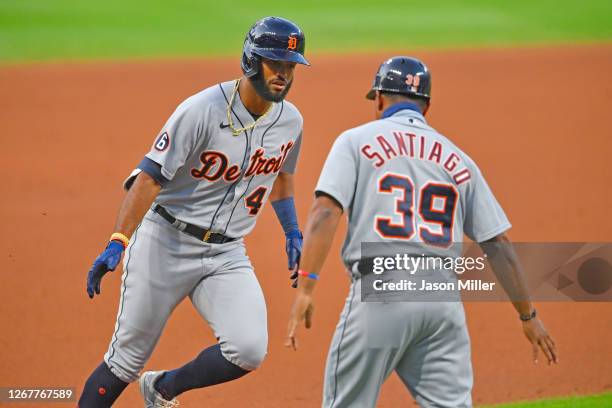 Willi Castro of the Detroit Tigers celebrates with third base coach Ramon Santiago during the fourth inning against the Cleveland Indians at...