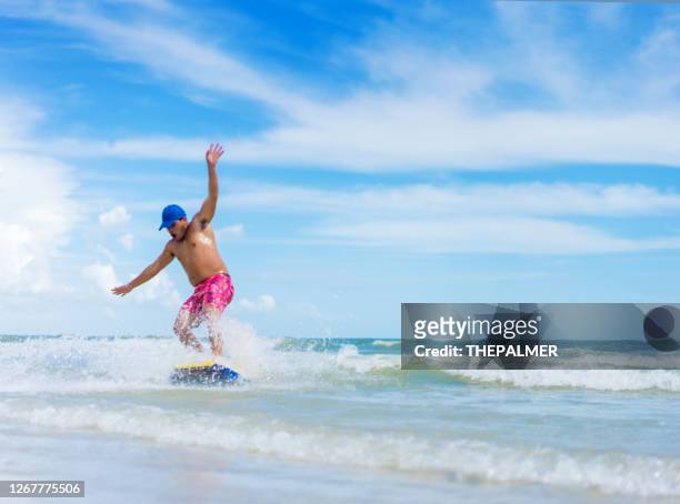 young hispanic man on skim board - fort myers stock pictures, royalty-free photos & images