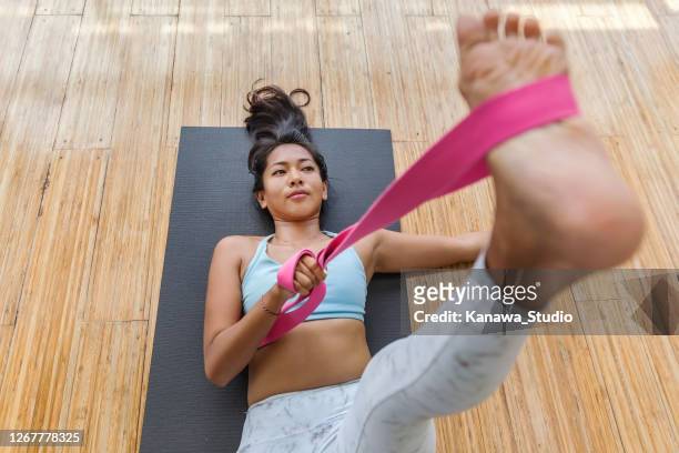 young asian woman using yoga strap to exercise flexibility - strap stock pictures, royalty-free photos & images