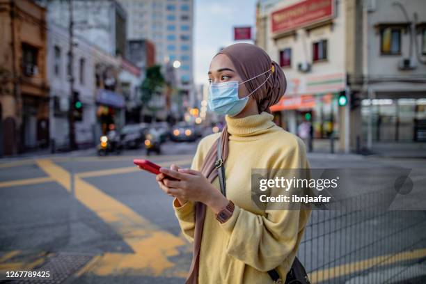 young asian girl using phone - coronavirus travel stock pictures, royalty-free photos & images