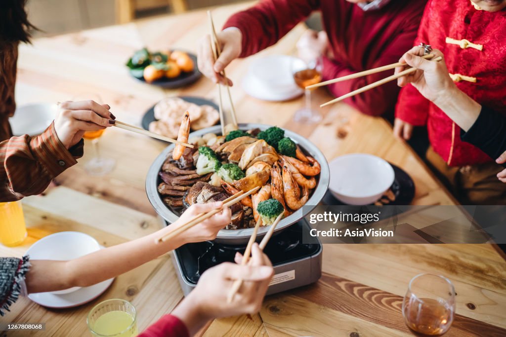 特寫三代歡樂的亞洲家庭歡度中國新年,在團圓晚宴上享受美味的中國傳統美食。
