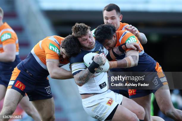 Josh McGuire of the North Queensland Cowboys is tackled by the Knights defence during the round 15 NRL match between the Newcastle Knights and the...