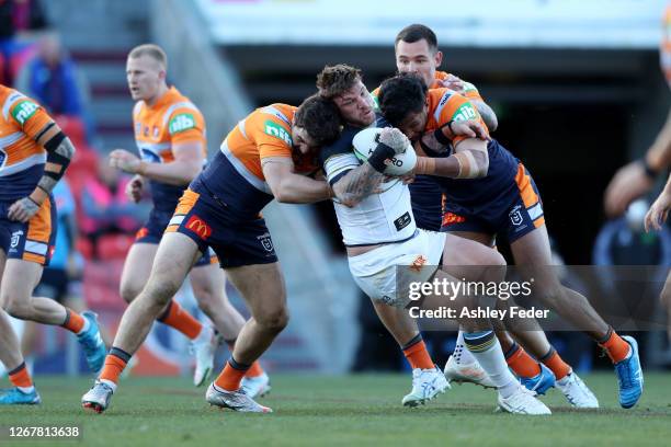 Josh McGuire of the North Queensland Cowboys is tackled by the Knights defence during the round 15 NRL match between the Newcastle Knights and the...