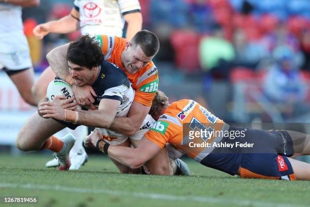 Jake Granville of the North Queensland Cowboys is tackled during the round 15 NRL match between the Newcastle Knights and the North Queensland...