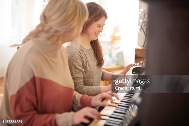 mother and daughter playing piano - pianist stock pictures, royalty-free photos & images