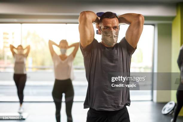 group of women exercising with male trainer in the gym - reopening business - gym reopening stock pictures, royalty-free photos & images