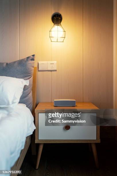 close-up of wireless audio on night table - bedside table lamp stock pictures, royalty-free photos & images