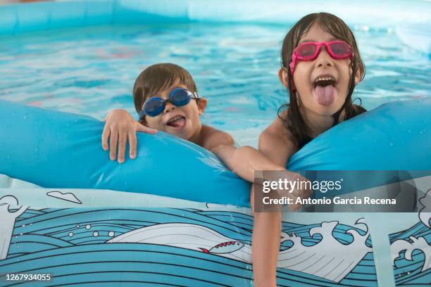 brothers play in the plastic pool in their garden - plastic pool stockfoto's en -beelden