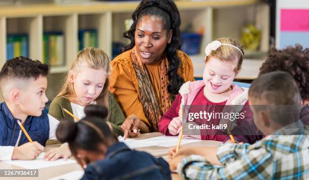 elementary school classroom, girl with down syndrome - criança de escola primária imagens e fotografias de stock