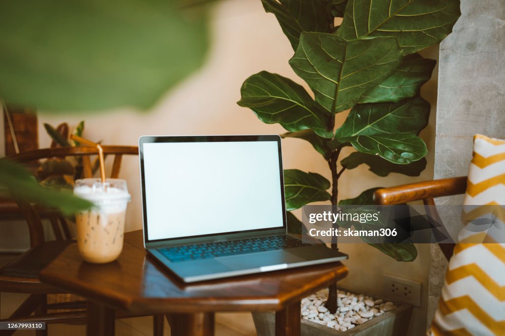Side angle view of blank screen laptop computer on wooden table
