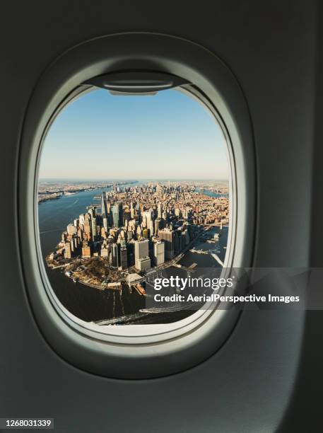 manhattan skyline from the porthole of aircraft, aerial view - flugzeugsitz stock-fotos und bilder