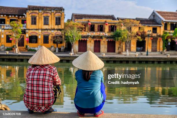 vietnamese vrouwen die oude stad in hoi een stad, vietnam bekijken - hoi an stockfoto's en -beelden