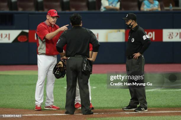 Head coach, Matt Williams of KIA Tigers talks with umpires as he protests Infielder Kim Woong-Bin of Kiwoom Heroes slides safely into the home plate...
