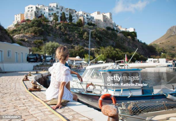 woman sitting at the waterfront of small italian beach town - sperlonga foto e immagini stock
