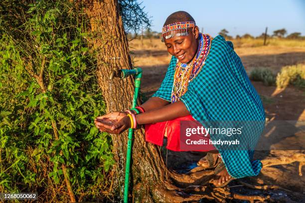 mujer africana de la tribu masái agua potable, kenia, africa oriental - a beautiful masai woman fotografías e imágenes de stock